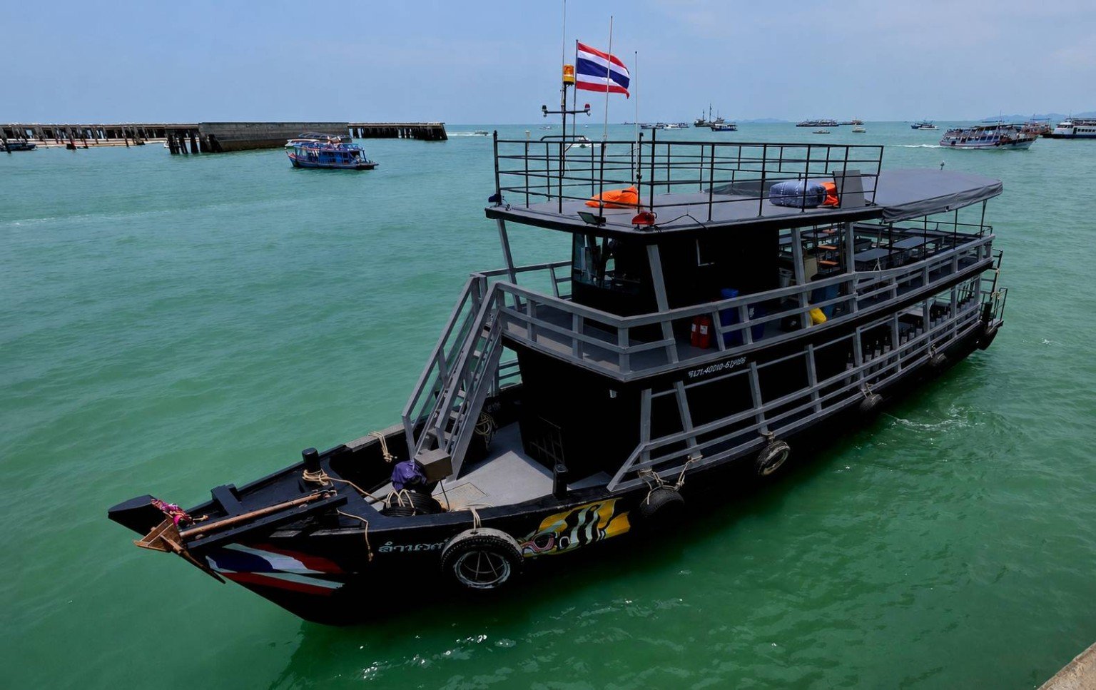 Copperband 1, Copperband Scuba Academy’s black and silver dive boat, moored off Pattaya with a Thai flag